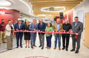a group of people cutting a ribbon