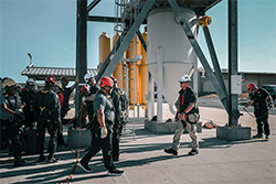 Workers standing near a large grain hopper