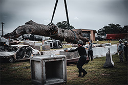 Rescurer using crane to move fallen tree