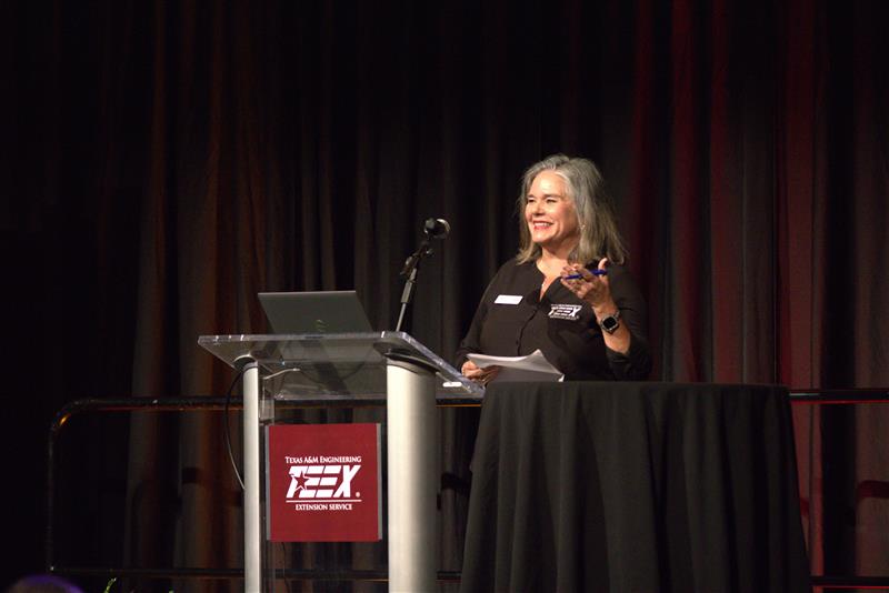 a women standing behind a podium speaking