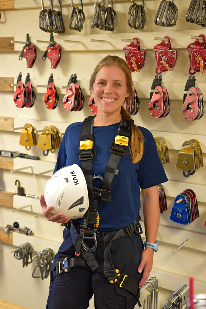 Shannon Mauras standing in front of a helmet wall