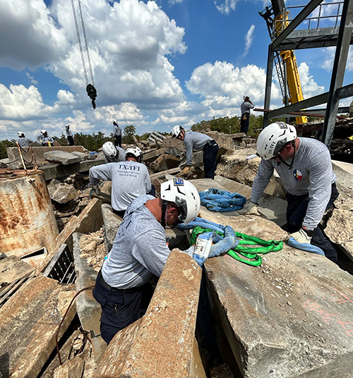 a group of men searching in a rubble pile