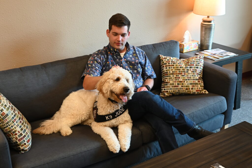 a man sitting with a dog on a couch