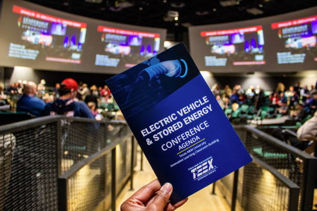Person holding a flyer in a room of people