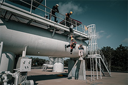 Workers on top of a large metal prop