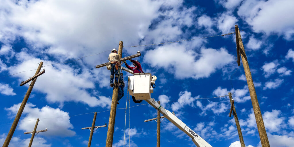 people working on a line pole