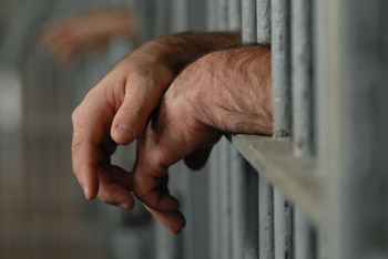 Inmate hands in jail cell
