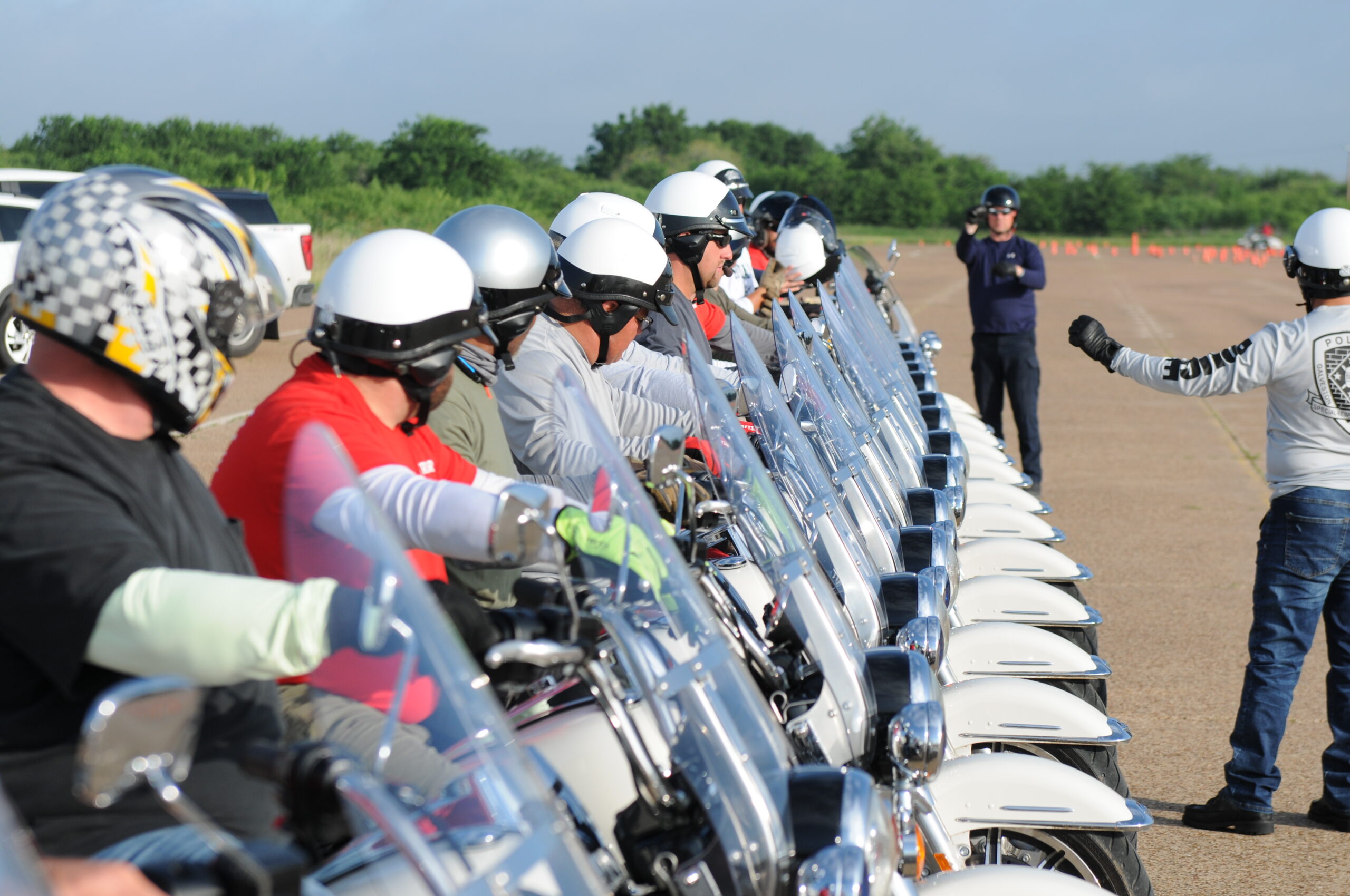 Instructor at the line with students learning to ride motorcycles