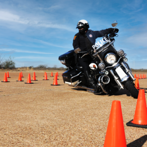 Police officer riding motorcycle through road cones