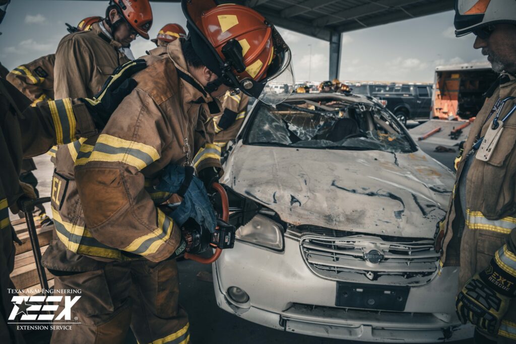 firefighters using the jaws of life to cut open a car