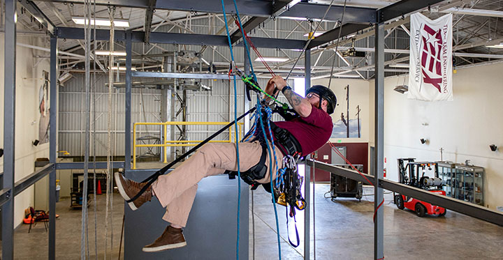 TEEX instructor demonstrates rope access techniques in TEEX Utilities Training Hangar.