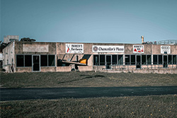 Wide view of a strip mall with many stores that looks deserted