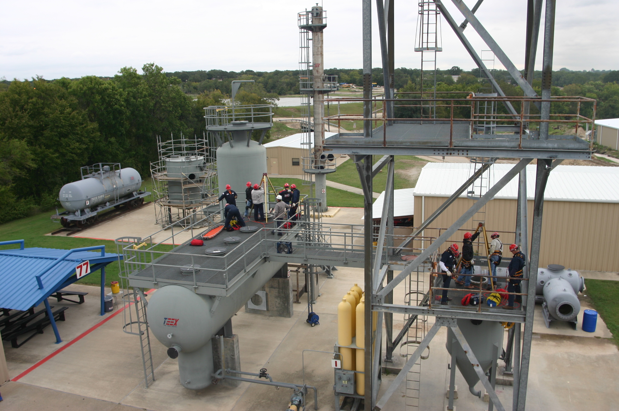 workers rescue a person from a confined space atop a metal structure