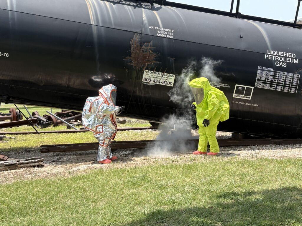 two people in hazmat suites near a train