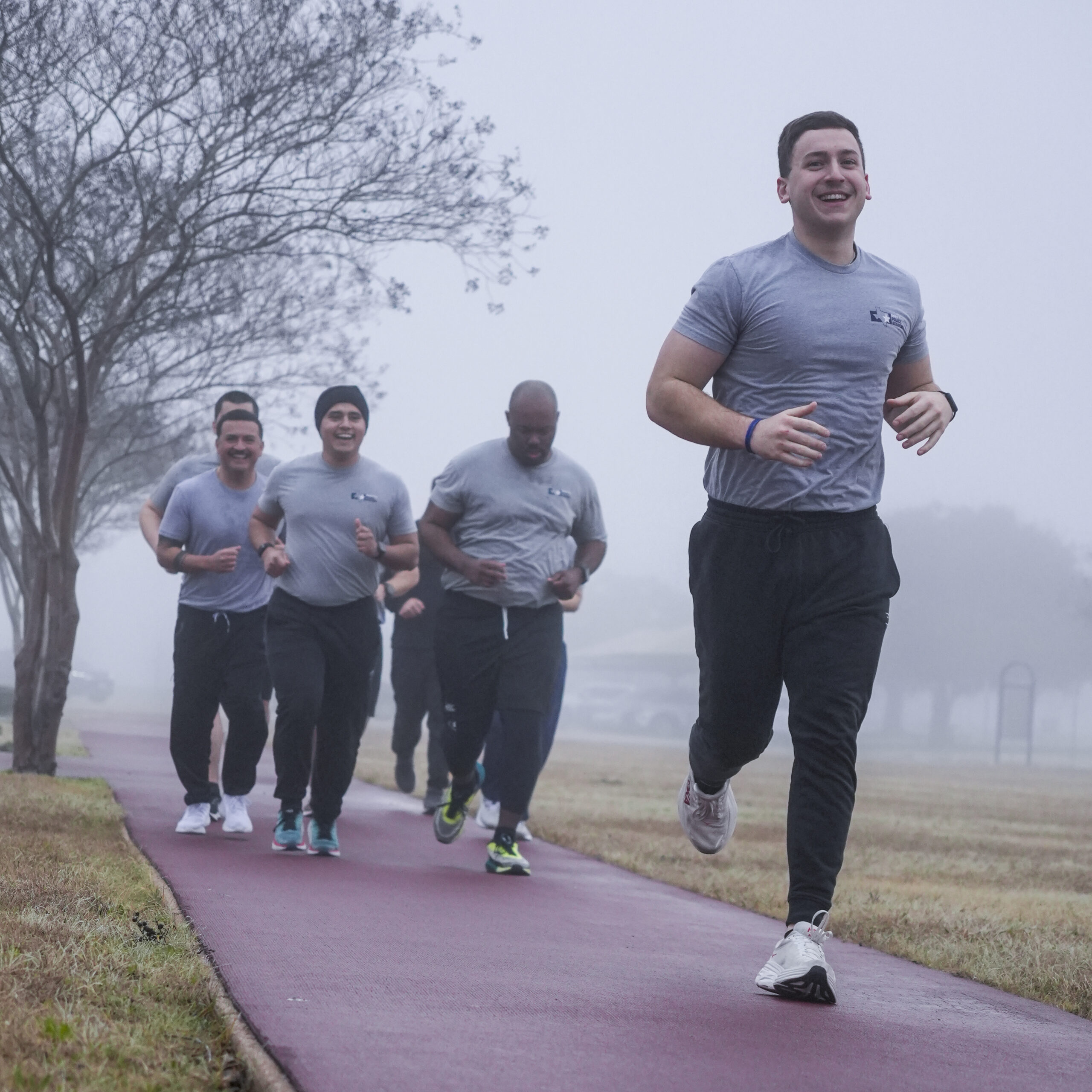 smiling runners in the fog