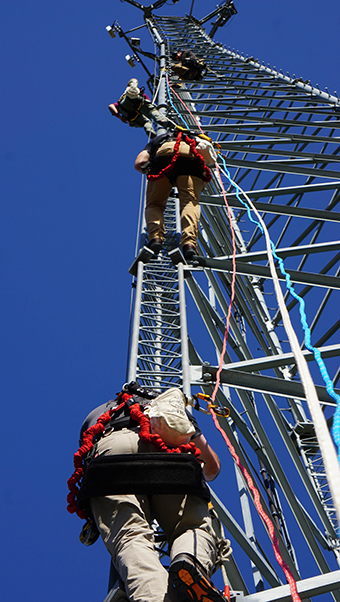 three TEEX tower technician course participants climb a tower.